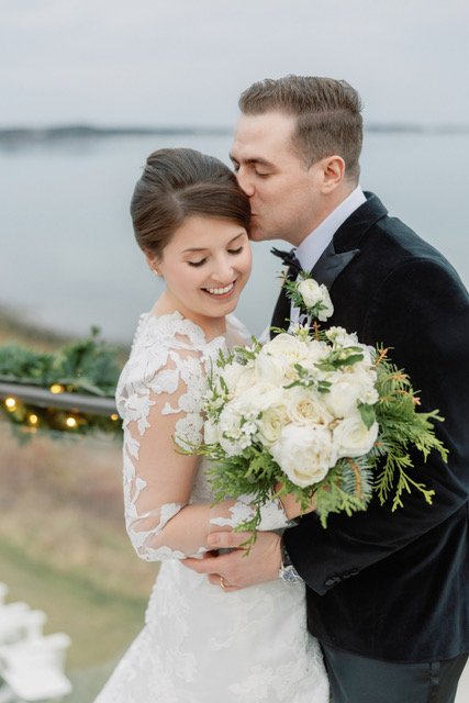 Couple with an all-white winter bridal bouquet