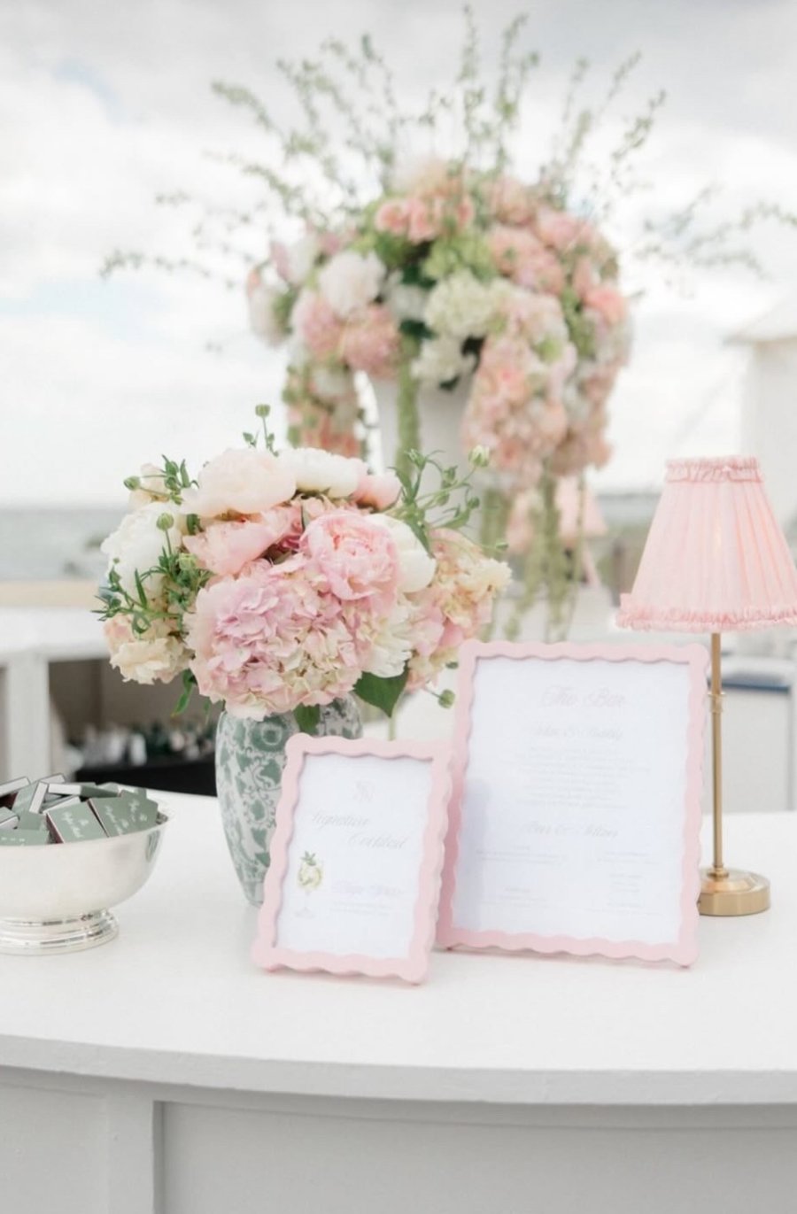 Bar signage with peonies and a pink pleated lamp