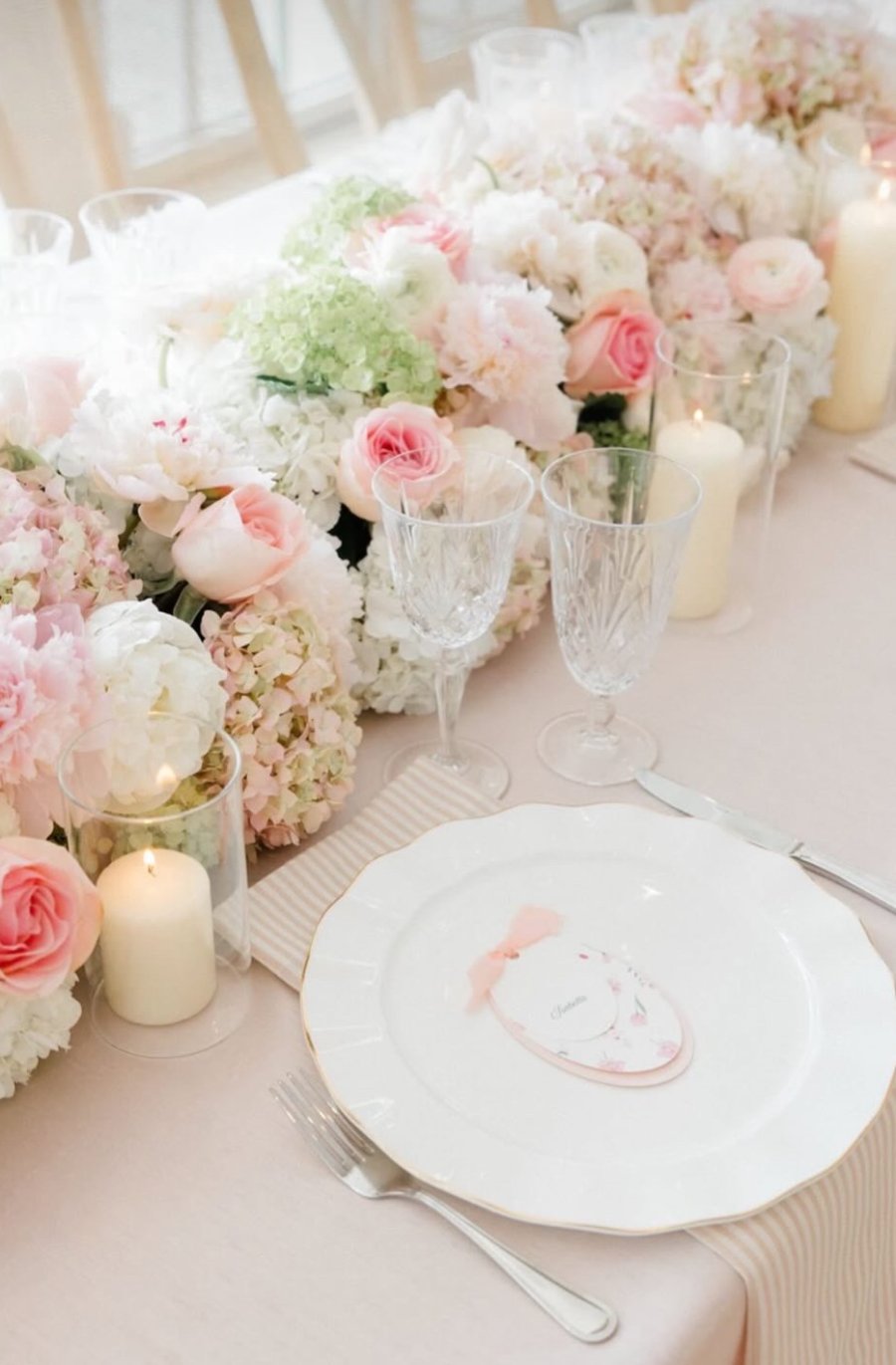 Place setting beside a blush and white floral runner