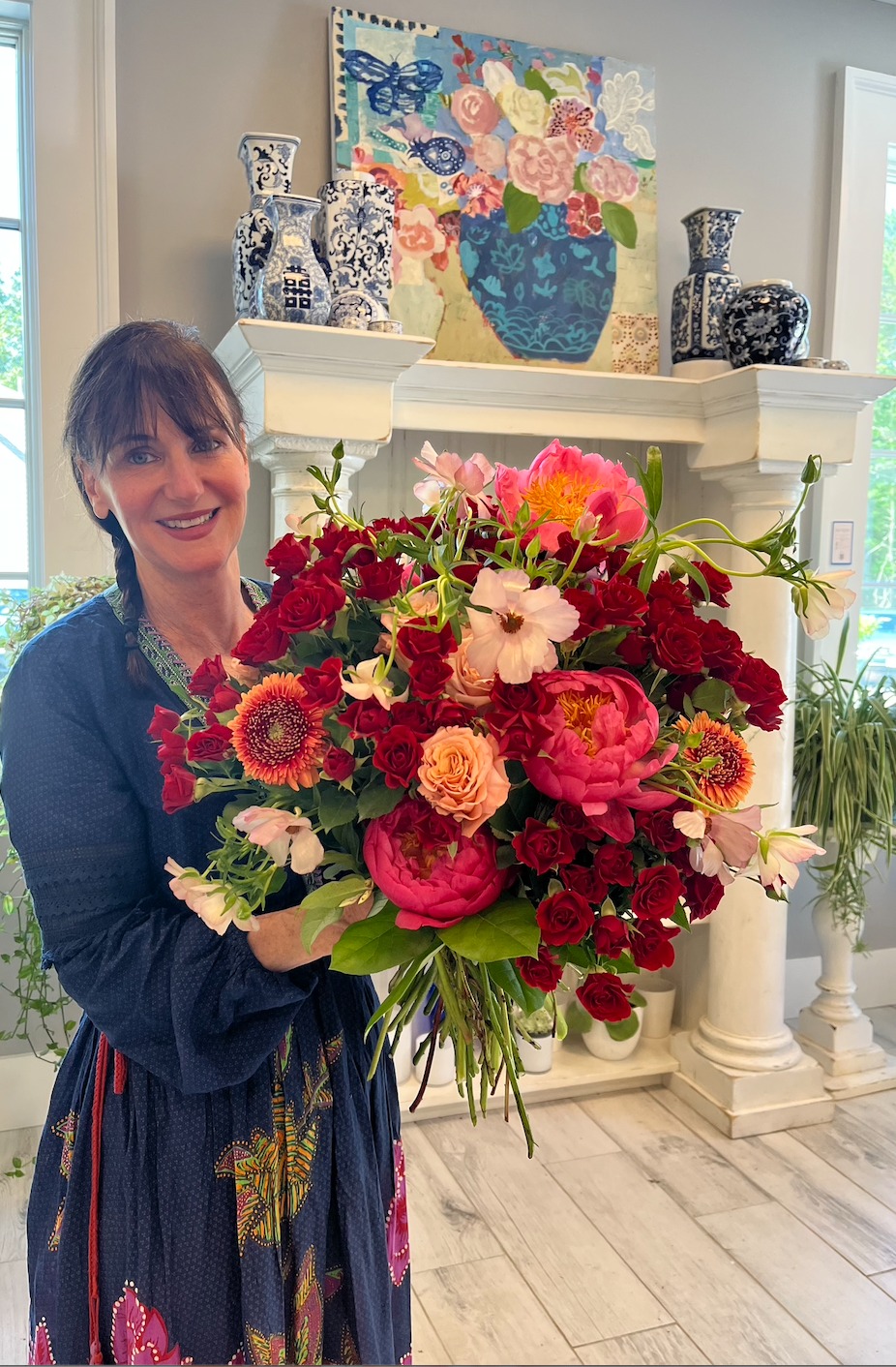 Karyn in the shop holding an arrangement of peonies and garden roses