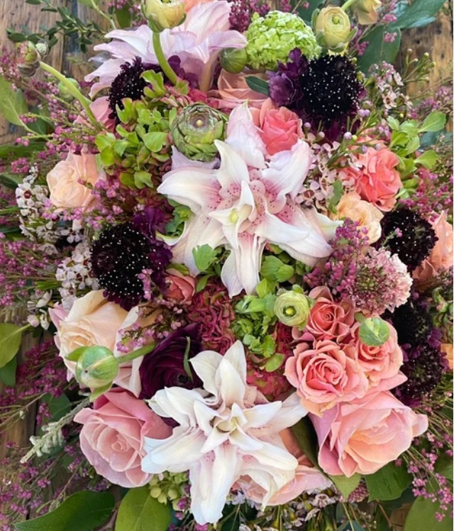 Peach and plum arrangement with lilies, garden roses, scabiosa and waxflower